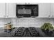 This kitchen features modern appliances, sleek black countertops, and stylish white subway tile backsplash at 2321 Norbury Se Cv, Smyrna, GA 30080