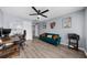 Home office/study area with a desk, blue velvet couch, ceiling fan and multiple windows creating a bright workspace at 2321 Norbury Se Cv, Smyrna, GA 30080