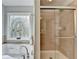 Beautiful bathroom featuring a soaking tub with decorative window and step-in shower with glass door at 475 Bayswater Way, Suwanee, GA 30024
