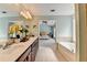 Bright bathroom featuring a double vanity, a large soaking tub, and an open doorway to the bedroom at 475 Bayswater Way, Suwanee, GA 30024