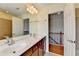 This bathroom features a double vanity, a large mirror and stairs in the background at 475 Bayswater Way, Suwanee, GA 30024