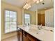 This bathroom features a double vanity, a large mirror and natural light from the window at 475 Bayswater Way, Suwanee, GA 30024