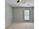 Empty bedroom painted gray features ceiling fan and window that allows natural light to fill the room at 475 Bayswater Way, Suwanee, GA 30024