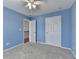 Bright bedroom painted blue with a closet, doorway to the stairs and natural light from the window at 475 Bayswater Way, Suwanee, GA 30024