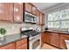 Kitchen with stainless steel gas range, microwave, tile backsplash, granite countertop and plenty of cabinets at 475 Bayswater Way, Suwanee, GA 30024