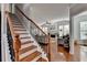 Open staircase with hardwood steps and wrought iron railing leading to the main level at 475 Bayswater Way, Suwanee, GA 30024