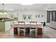 Dining area with a long table and chairs offers views of the backyard and open flow to the kitchen at 4975 Skyland Pkwy, Cumming, GA 30028