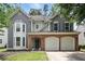 Charming two-story home featuring a brick facade, gray siding, and a two-car garage at 4975 Skyland Pkwy, Cumming, GA 30028