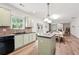 Open kitchen showcases light green cabinets, a center island, and a seamless transition to the dining area at 4975 Skyland Pkwy, Cumming, GA 30028