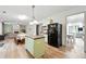 Open-concept kitchen boasts modern appliances, island with seating, and seamless flow to the living area at 4975 Skyland Pkwy, Cumming, GA 30028