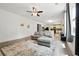 Inviting living room with a plush gray sofa, light wood flooring, and natural light from a large window at 4975 Skyland Pkwy, Cumming, GA 30028