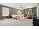 Spacious main bedroom featuring plush carpeting, natural light, and ample space for seating at 4975 Skyland Pkwy, Cumming, GA 30028