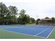 Well-maintained tennis court surrounded by lush trees, offering recreational opportunities at 4975 Skyland Pkwy, Cumming, GA 30028