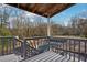 Balcony with grey floors, light grey railing, and view of pool and wooded backyard at 130 Thornton Dr, Fayetteville, GA 30214