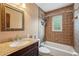 Bathroom featuring tiled shower-tub combo, granite vanity, and decorative mirror at 130 Thornton Dr, Fayetteville, GA 30214