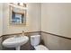 Bathroom featuring a pedestal sink, toilet, mirror, and decorative trim at 130 Thornton Dr, Fayetteville, GA 30214