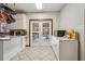 Eat-in kitchen features tile floor, white cabinetry, and French doors to backyard deck and pool at 130 Thornton Dr, Fayetteville, GA 30214