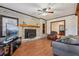 Bright and airy living room with a striking brick fireplace, wooden mantel, and laminate flooring at 130 Thornton Dr, Fayetteville, GA 30214