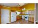 Well-lit kitchen boasts a full suite of appliances, wood cabinets, and a bright, sunny yellow accent wall at 210 Overview Ct, Villa Rica, GA 30180