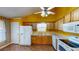 Bright kitchen with white appliances and oak cabinets under a vaulted ceiling is the heart of the home at 210 Overview Ct, Villa Rica, GA 30180