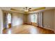 Spacious main bedroom features hardwood flooring, tray ceiling with fan, and natural light from two large windows at 210 Overview Ct, Villa Rica, GA 30180