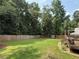 Large backyard with a playhouse, trampoline, deck, and mature trees at 2193 Kildare Nw Way, Kennesaw, GA 30152