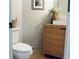 Modern half bath with a vessel sink, light wood cabinet, framed art, and a round mirror enhances the room at 2193 Kildare Nw Way, Kennesaw, GA 30152