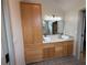 Bathroom with double sinks, modern lighting, wood cabinets, and tile floors at 2193 Kildare Nw Way, Kennesaw, GA 30152