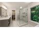 Modern bathroom with a glass shower, marble tile and a view into a lush green backyard at 3275 Lord N Lady Ln, Alpharetta, GA 30022