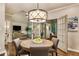 Dining area with modern light fixture next to french doors and view into the living room at 3275 Lord N Lady Ln, Alpharetta, GA 30022
