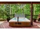 Back deck with hot tub, string lights, potted plants, and wooded views at 3275 Lord N Lady Ln, Alpharetta, GA 30022