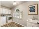 Functional laundry room with modern appliances, cabinets, and a utility sink for added convenience at 3275 Lord N Lady Ln, Alpharetta, GA 30022