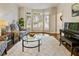 Bright living room featuring a bay window, hardwood floors, a piano, and comfortable seating at 3275 Lord N Lady Ln, Alpharetta, GA 30022
