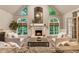Inviting living room featuring high ceilings, fireplace, large windows, and comfortable seating arrangement at 3275 Lord N Lady Ln, Alpharetta, GA 30022