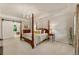Spacious main bedroom featuring a four-poster bed, barn door entrance to the bathroom, and plush carpet at 3275 Lord N Lady Ln, Alpharetta, GA 30022