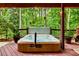 Outdoor hot tub on a wood deck surrounded by lush greenery and string lights at 3275 Lord N Lady Ln, Alpharetta, GA 30022