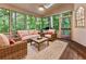 Relaxing screened-in porch with comfortable seating, wooded views, and a ceiling fan for hot days at 3275 Lord N Lady Ln, Alpharetta, GA 30022