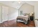 Cozy bedroom with vaulted ceiling, hardwood floors, comfortable bed, and a bedside table at 4515 Ambassador Way, Cumming, GA 30040