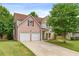 Charming two-story home featuring a two-car garage, well-maintained lawn, and lush trees at 4515 Ambassador Way, Cumming, GA 30040