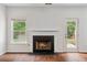 Living room featuring a fireplace, white mantle, windows, and access to the backyard at 4515 Ambassador Way, Cumming, GA 30040