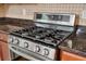 A stainless steel gas stove with granite countertops and tile backsplash at 4515 Ambassador Way, Cumming, GA 30040
