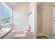 Bright bathroom featuring a tub, shower, and large window offering natural light at 4578 Score Ct, Snellville, GA 30039
