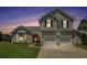 Two-story home with lovely landscaping, bay window, and attached two car garage at dusk at 4578 Score Ct, Snellville, GA 30039
