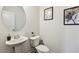 Cozy powder room featuring pedestal sink, modern fixtures, and decorative artwork at 178 Munira Sw Ln, Atlanta, GA 30331