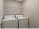 Practical laundry room with a washing machine and dryer, and a wire shelf for storage at 2907 Timbercreek Cir, Roswell, GA 30076
