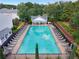 Aerial view of a refreshing community pool, complete with lounge chairs, tables, and a covered pavilion for relaxation at 2907 Timbercreek Cir, Roswell, GA 30076