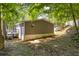 Backyard of a home featuring a wooden deck, surrounded by lush greenery and mature trees at 6235 Akins Way, Cumming, GA 30041