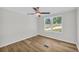 Bright bedroom with wood-look floors, a ceiling fan, and a large window overlooking the lawn at 6235 Akins Way, Cumming, GA 30041