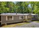 Single-story home featuring a metal roof, gray siding, and a welcoming front porch at 6235 Akins Way, Cumming, GA 30041