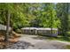 View of a home on a tree-lined lot with long driveway, showcasing its idyllic setting at 6235 Akins Way, Cumming, GA 30041